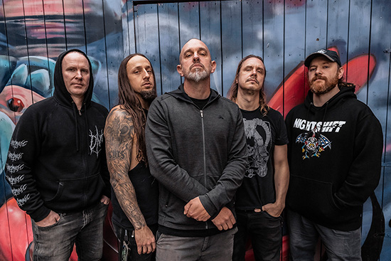 Участники Psycroptic стоят перед стеной с красно-синим граффити